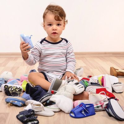 bebé rodeado de zapatos