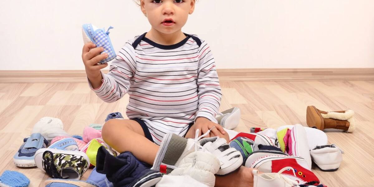 bebé rodeado de zapatos